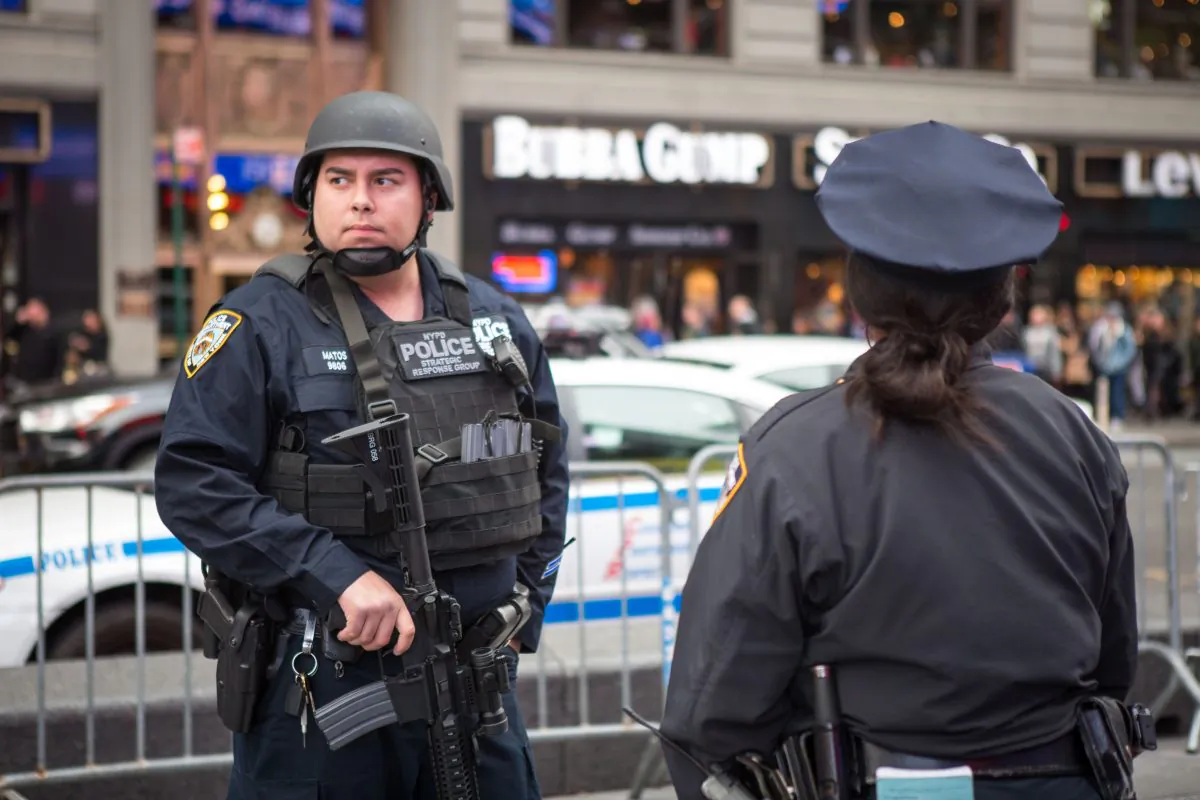 A Member of the NYPD Strategic Response Group and an NYPD officer stand guard in New York's Times Square on Nov. 18, 2015. Police officials said they've deployed extra units to crowded areas of the city in the wake of the Paris terror attacks. (Benjamin Chasteen/Epoch Times)