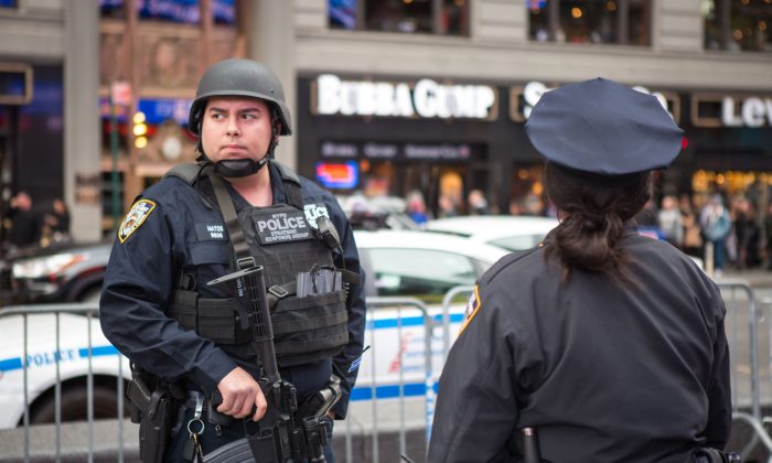 A Member of the NYPD Strategic Response Group and an NYPD officer stand guard in New York's Times Square on Nov. 18, 2015. Police officials said they've deployed extra units to crowded areas of the city in the wake of the Paris terror attacks. (Benjamin Chasteen/Epoch Times)