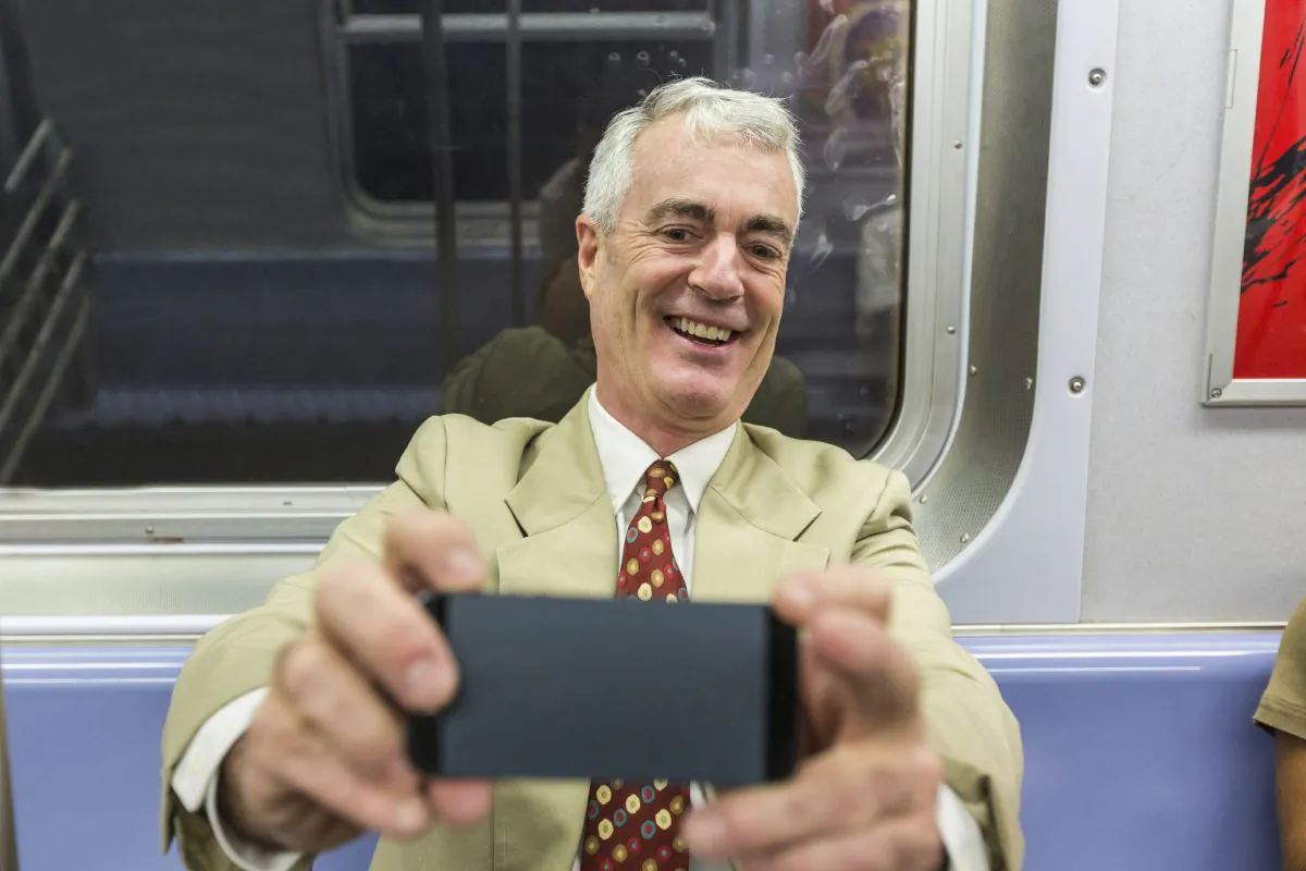Senior Businessman Taking a Selfie in the Subway Train