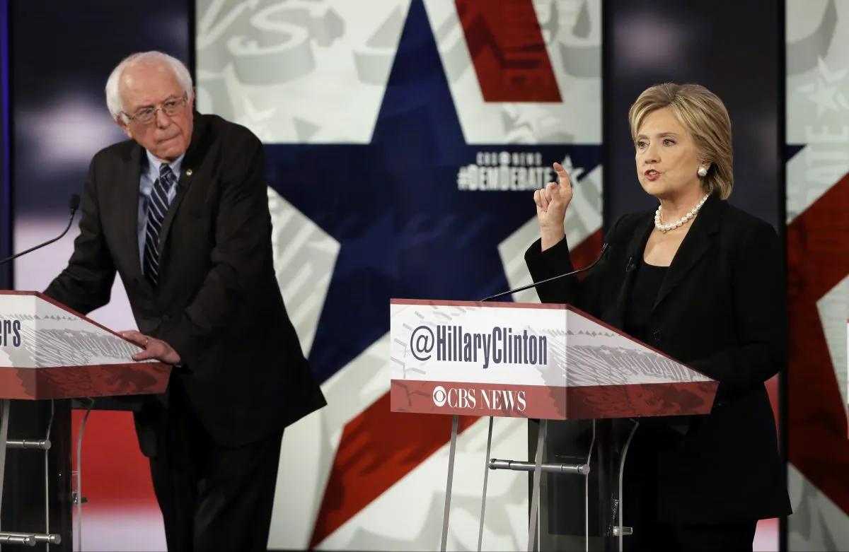 In this Nov. 14, 2015, photo, Hillary Rodham Clinton, right, makes a point as Bernie Sanders listens during a Democratic presidential primary debate in Des Moines, Iowa. (AP Photo/Charlie Neibergall)