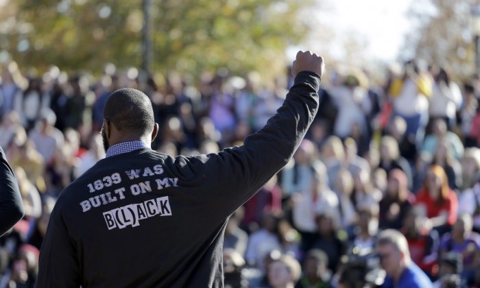 In this Nov. 9, 2015 file photo, a member of the black student protest group Concerned Student 1950 gestures while addressing a crowd following the announcement that University of Missouri System President Tim Wolfe would resign, at the university in Columbia, Mo. (AP Photo/Jeff Roberson)