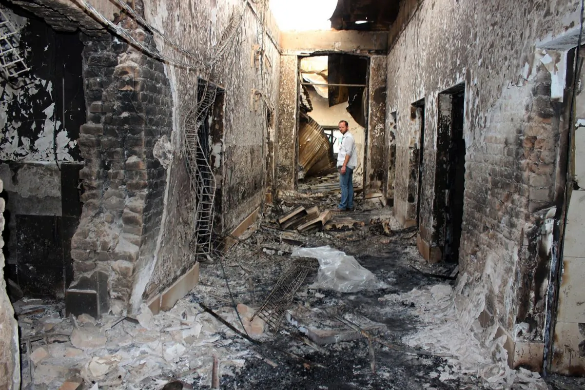An employee of Doctors Without Borders stands inside the charred remains of their hospital after it was hit by a U.S. airstrike in Kunduz, Afghanistan, on Oct. 16, 2015. (Najim Rahim via AP)
