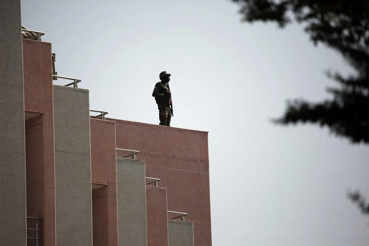 Tight security surrounds Malian President Ibrahim Boubacar Keita as he visits the Radisson Blu hotel in Bamako, Mali, Saturday, Nov. 21, 2015. Malian security forces were hunting "more than three" suspects after a brazen assault on a luxury hotel in the capital that killed at least 19 people plus two assailants, an army commander said Saturday. (AP Photo/Jerome Delay)