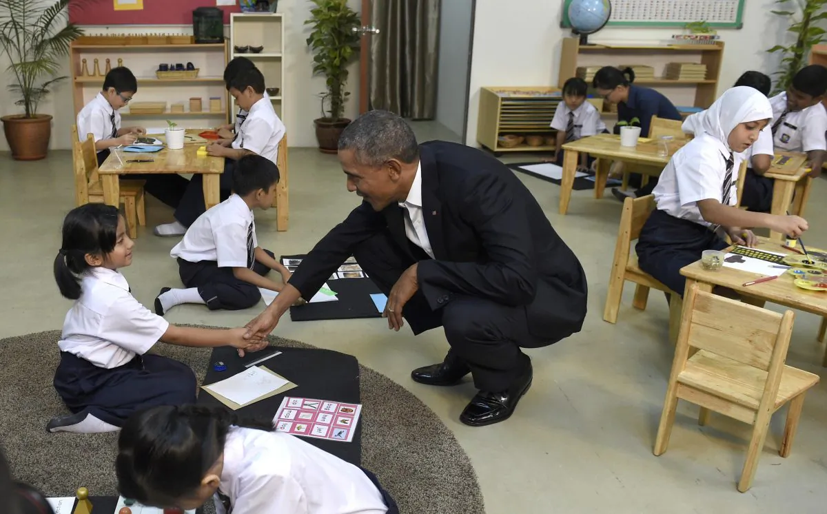 President Barack Obama (C) shakes hands with a girl as he tours the Dignity for Children Foundation in Kuala Lumpur, Malaysia, Saturday, Nov. 21, 2015. Obama visited the center in Malaysia that helps lower income families including refugees, casting a spotlight on the plight of those fleeing violence and persecution from Burma to Syria. (AP Photo/Susan Walsh)