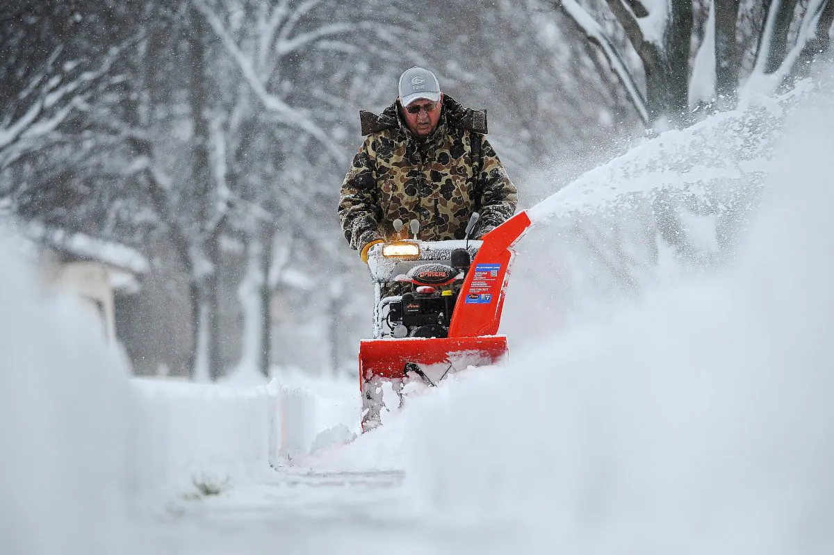 Harvey Wollman uses a snow blower to clear the sidewalk near his house during the first snow of the season Friday, Nov. 20, 2015, in Sioux Falls, S.D. (Joe Ahlquist/The Argus Leader via AP)