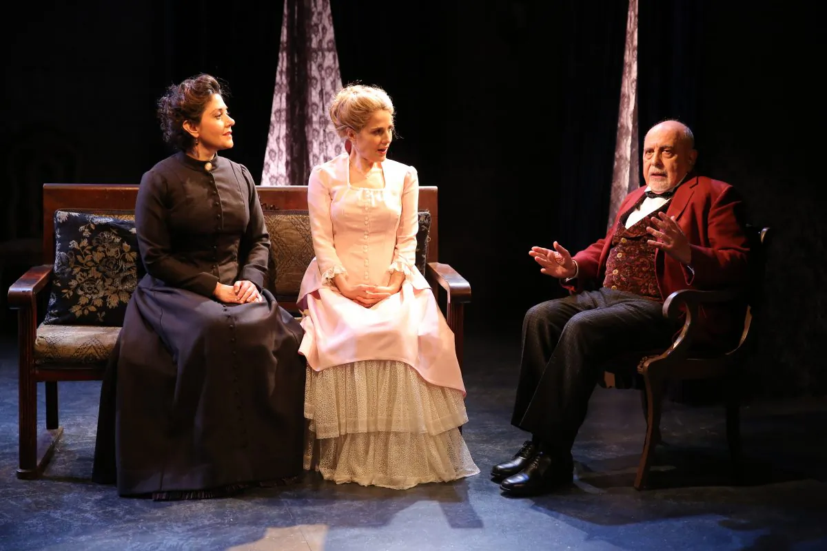 (L–R) An old friend Christine Lind (Andrea Cirie) visits Nora (Jean Lichty) as does a family friend Dr. Rank (George Morfogen), in “Nora.” (Carol Rosegg)
