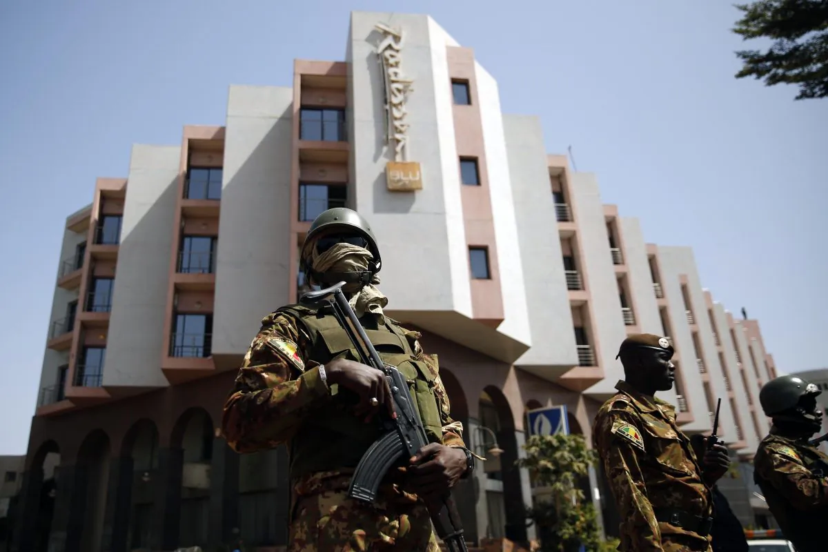Tight security surrounds Malian President Ibrahim Boubacar Keita as he visits the Radisson Blu hotel in Bamako, Mali, on Nov. 21, 2015. (AP Photo/Jerome Delay)