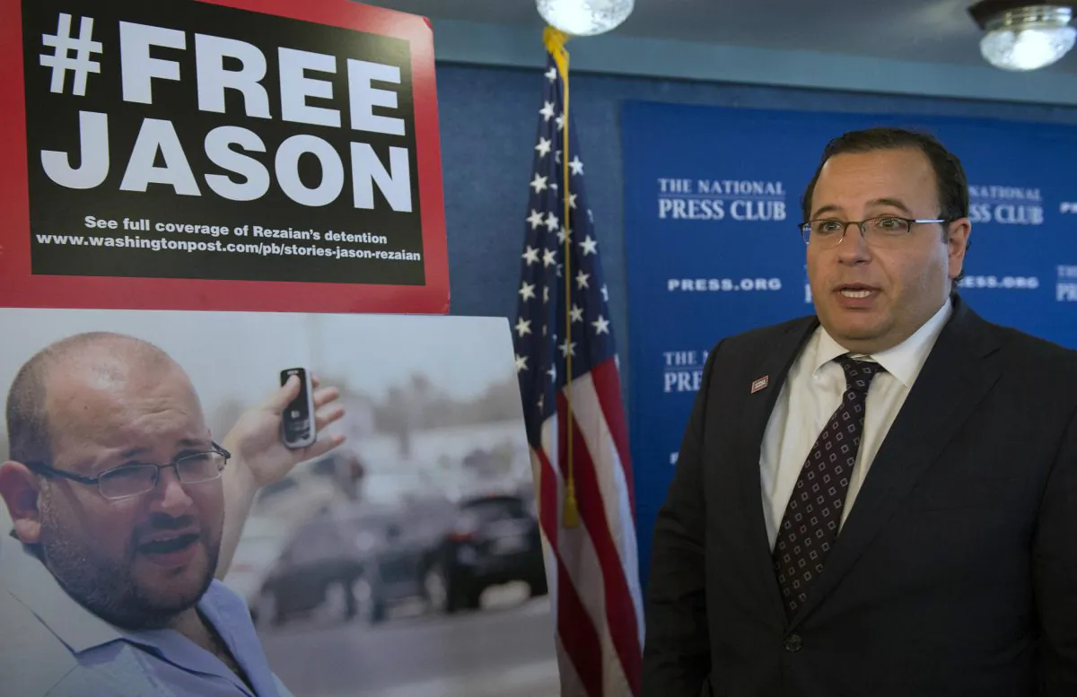 Ali Rezaian, brother of Jason Rezaian—an Iranian-American correspondent for the Washington Post—talks about the photo of his brother at a news conference at the National Press Club during update on the case in Washington, on July 22, 2015. Iran has sentenced detained Jason Rezaian to an unspecified prison term following his conviction last month on charges that include espionage, Iranian state TV reported Sunday. (AP Photo/Molly Riley)