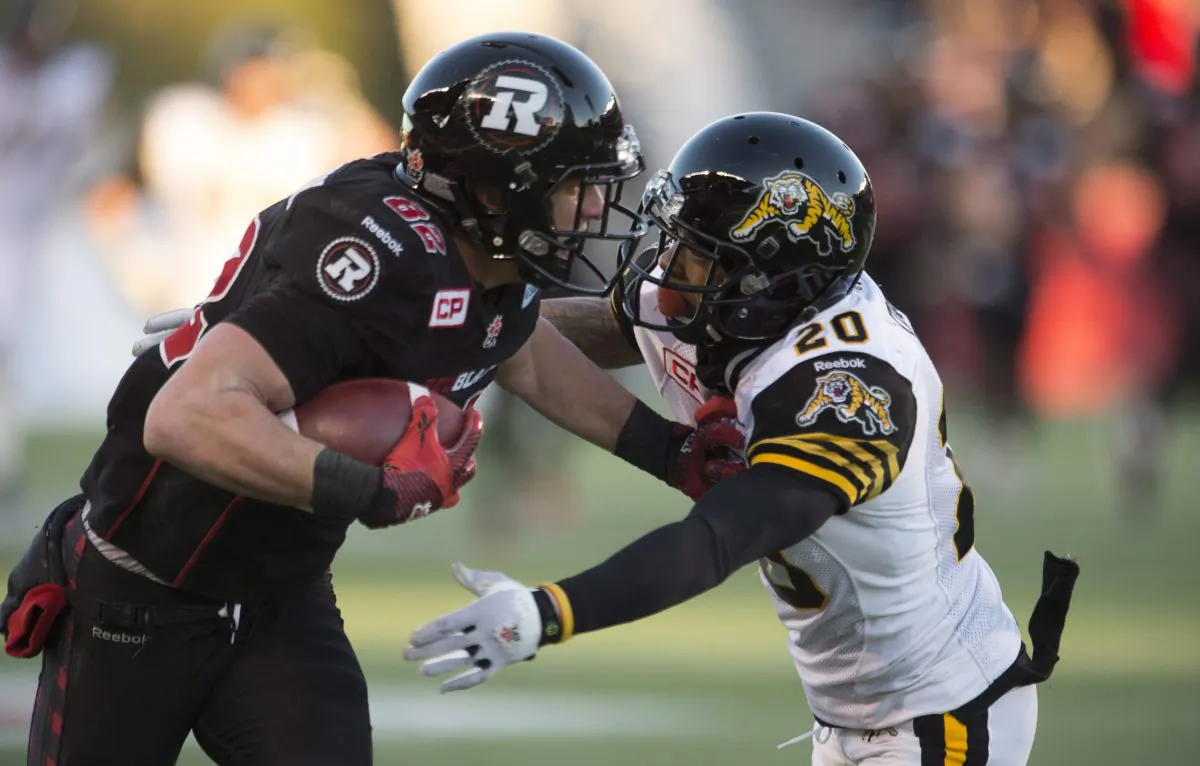 Ottawa Redblacks wide receiver Greg Ellingson fights off Hamilton Tiger-Cats defensive back Emanuel Davis as he runs for a touchdown in the fourth quarter in the CFL East Division final in Ottawa on Nov. 22, 2015. (The Canadian Press/Adrian Wyld)