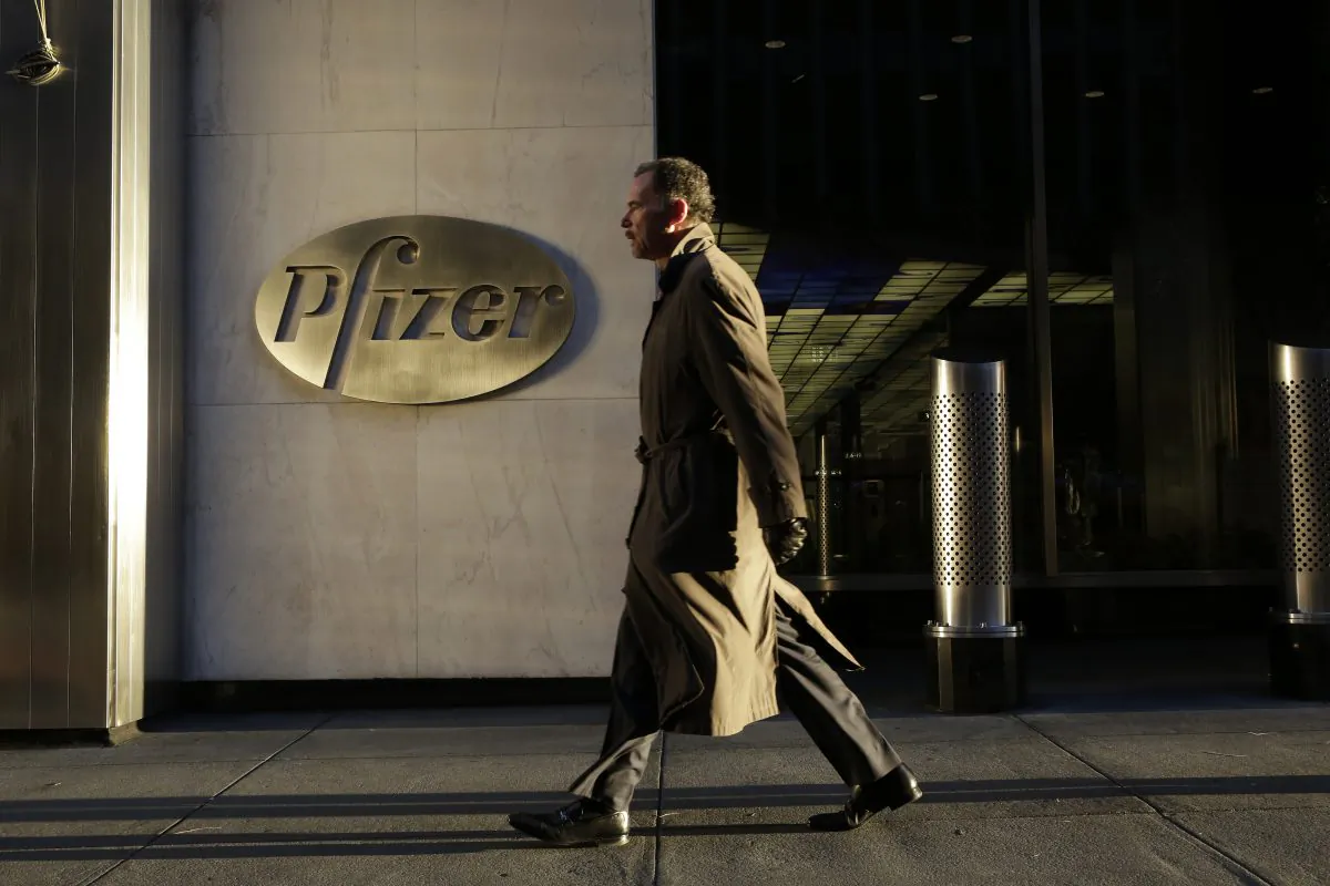 A man walks past Pfizer World Headquarters, Monday, Nov. 23, 2015 in New York. The new tax regulations blocked Pfizer from completing its proposed $160 billion merger deal with Ireland-based Allergan.  (AP Photo/Mark Lennihan)