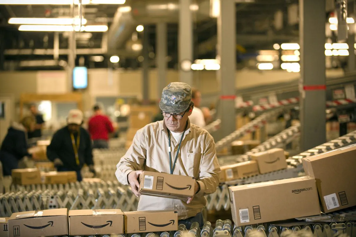 An Amazon employee grabs boxes off the conveyor belt to load in a truck at the company's Fernley, Nev., warehouse on Dec. 1, 2008. (Scott Sady/AP Photo)