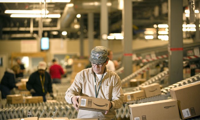 2008 年 12 月 1 日，亚马逊员工在内华达州 Fernley 的仓库中从传送带上抓起箱子装上卡车。（美联社照片/Scott Sady，档案）