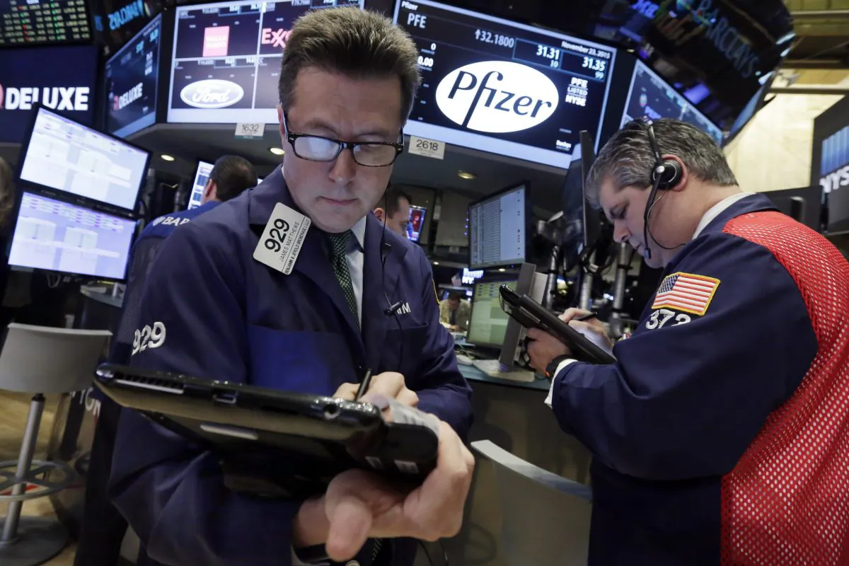 Traders James Matthews (L) and John Panin work at the post that handles Pfizer, on the floor of the New York Stock Exchange on Nov. 23, 2015. (AP Photo/Richard Drew)