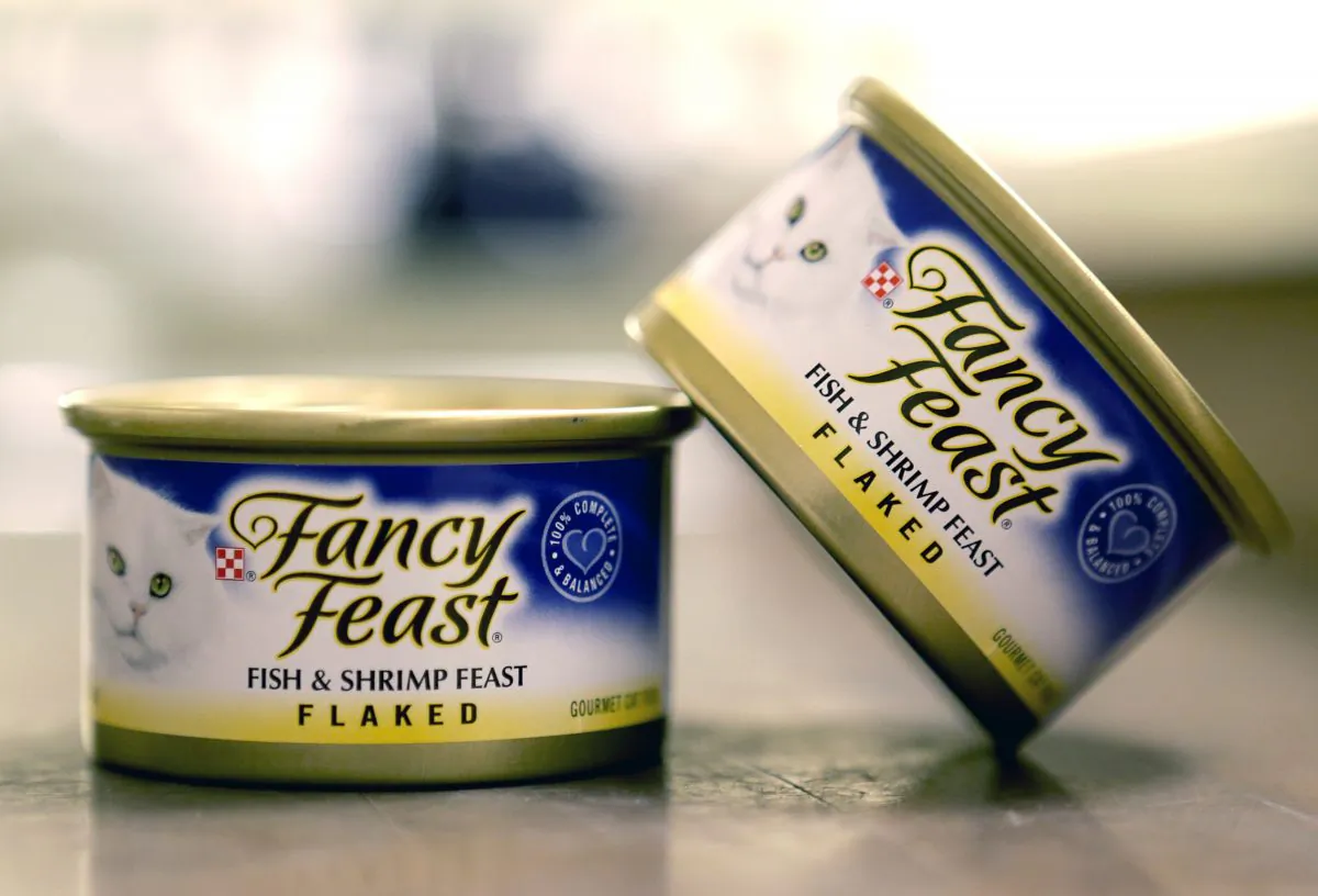 This Nov. 16, 2015, photo shows Fancy Feast cat food, fish and shrimp feast flavor, a product of Thailand, purchased at a Publix market in Orlando, Fla. A report commissioned by Nestle SA found that impoverished migrant workers in Thailand are sold or lured by false promises and forced to catch and process fish that ends up in the global food giant’s supply chains. Nestle is not a major purchaser of seafood in Southeast Asia but does some business in Thailand, primarily for its Purina brand Fancy Feast cat food. (AP Photo/John Raoux)