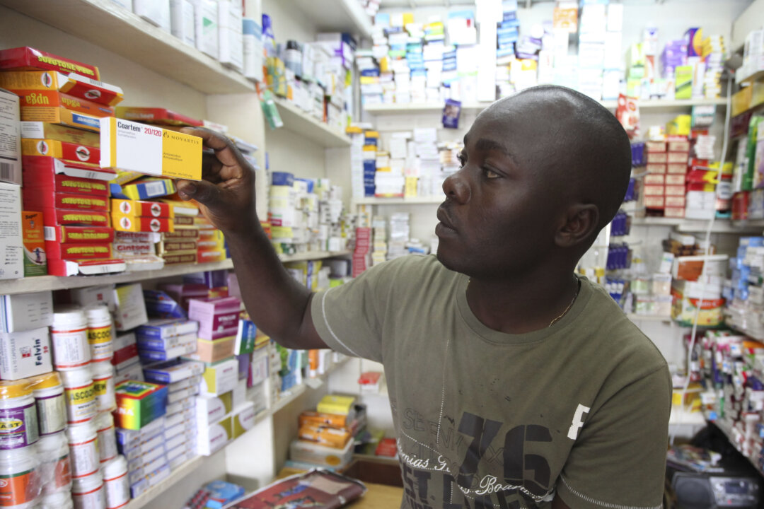 Ayo Bello displays a box of Coartem malaria medication, packaged for the commercial market, at a pharmacy in Lagos, Nigeria, on Aug. 30, 2010. Millions of free malaria drugs are sent to Africa every year by international donors. New research is now providing evidence for what health workers have long suspected: some of the donated medication, readily identifiable by its different packaging, is being stolen and resold on commercial markets. (AP Photo/Sunday Alamba)