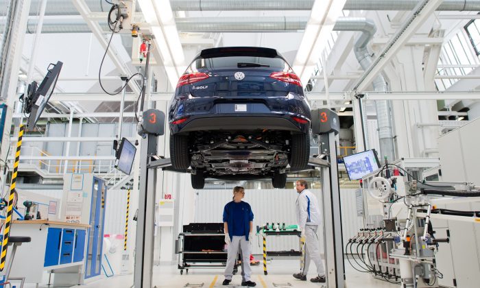 Employees of German carmaker Volkswagen (VW) work on an electric car e-Golf on an assembly line at VW plant in Wolfsburg, central Germany, on Oct. 21, 2015. (Julian Stratenschulte/AFP/Getty Images)