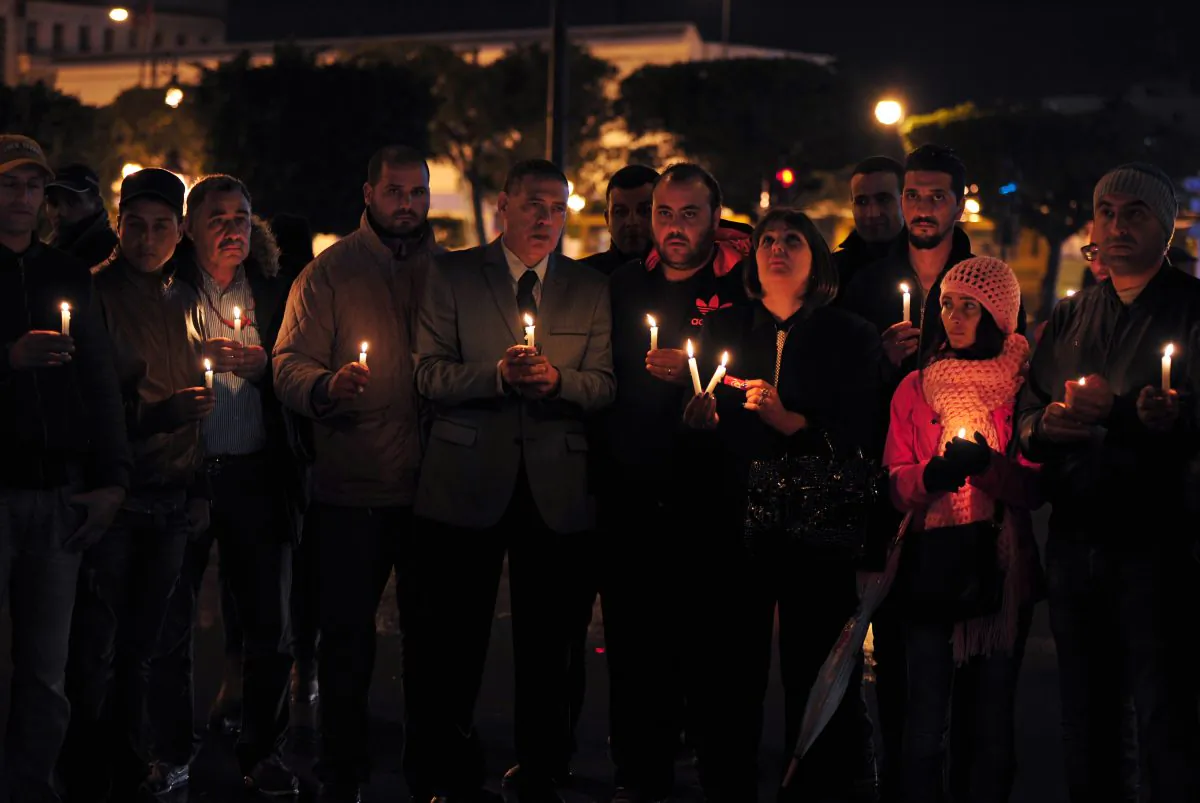 Tunisian Nidaa Tounes party members hold candles during a vigil in Tunis in memory of the victims of a bomb blast earlier in the day on a bus transporting Tunisia's presidential guard in the center of the Tunisian capital on Nov. 24, 2015. (Fethi Belaid/AFP/Getty Images)