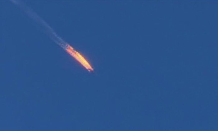 This frame grab from video by Haberturk TV, shows a Russian warplane on fire before crashing on a hill as seen from Hatay province, Turkey, Tuesday, Nov. 24, 2015. (Haberturk TV via AP)  
