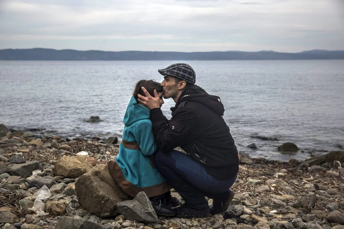 A Syrian man kisses his daughter shortly after disembarking from a dinghy at a beach on the Greek island of Lesbos after crossing the Aegean sea from the Turkish coast, Nov. 16, 2015. Experts say refugees are at a high-risk for mental health issues and often suffer spiked rates of depression and substance abuse. (AP Photo/Santi Palacios)