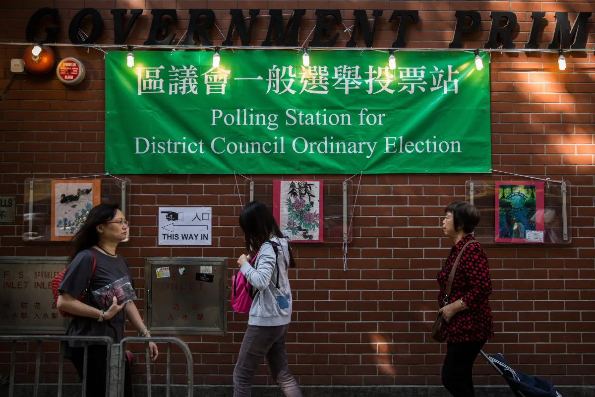 Voters walk past a polling station in the Wan Chai district of Hong Kong on Nov 22, 2015. Hong Kong went to the polls on Nov. 22 for the first time since huge pro-democracy protests gripped the city, in a key test of public sentiment. (Anthony WallaceE/AFP/Getty Images)