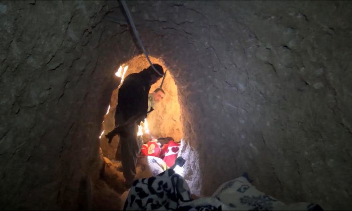 In this image made from video taken on Sunday, Nov. 22, 2015, Kurdish security forces are seen in a tunnel complex under the city of Sinjar, northern Iraq that were used by Islamic State extremists to move undetected and avoid coalition airstrikes. (AP Photo via AP video)