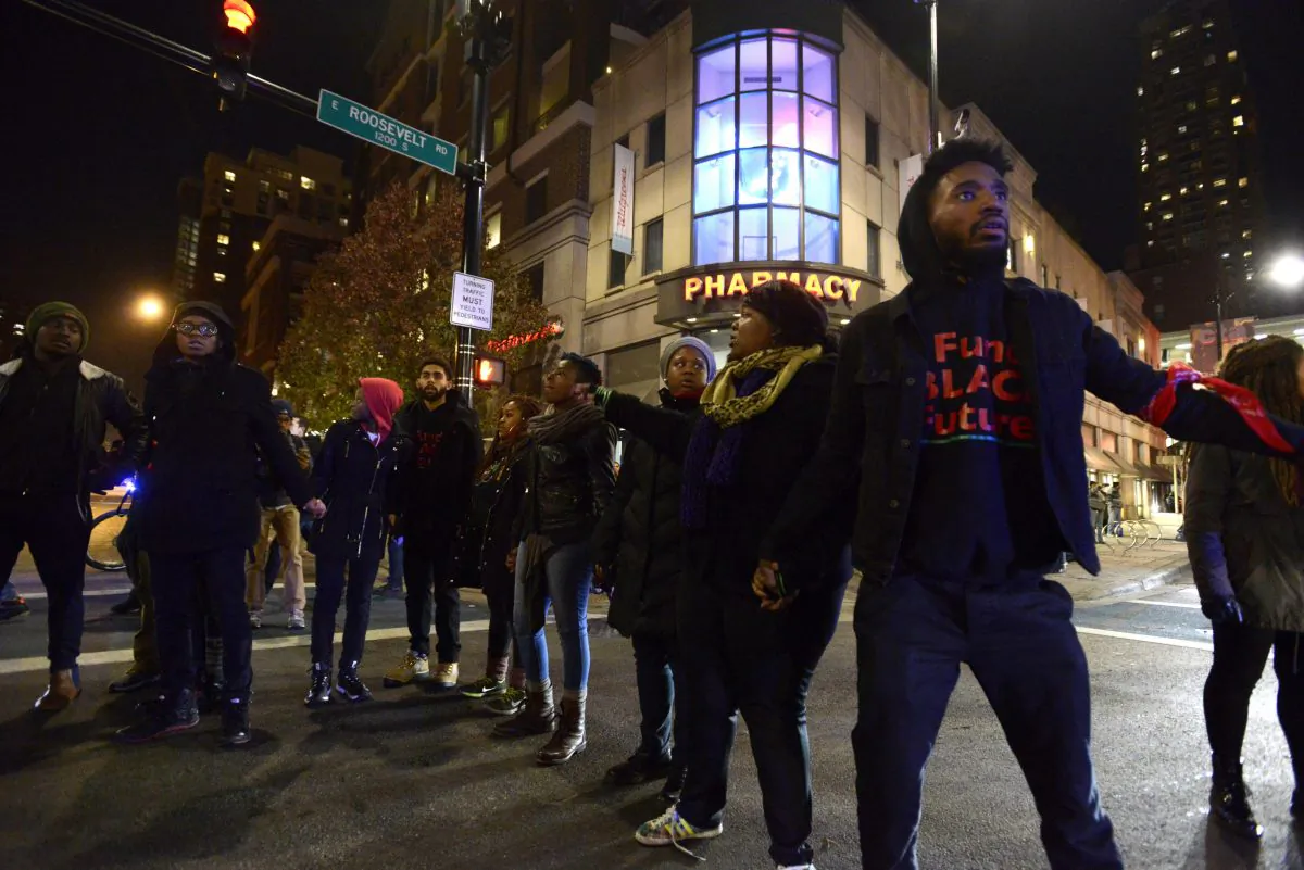 Protesters block a street during a protest for 17-year-old Laquan McDonald in Chicago on Nov. 24, 2015. Chicago police Officer Jason Van Dyke, who shot McDonald 16 times last year, was charged with first-degree murder Tuesday, hours before the city released a video of the killing. (AP Photo/Paul Beaty)