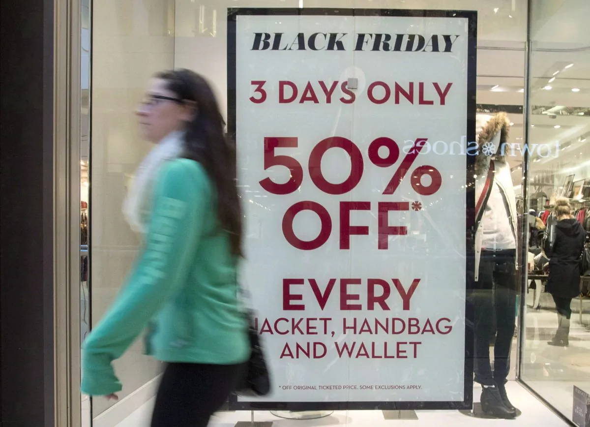 A woman passes a store advertising Black Friday sales at Ottawa's Bayshore Centre in this file photo. (The Canadian Press/Justin Tang)