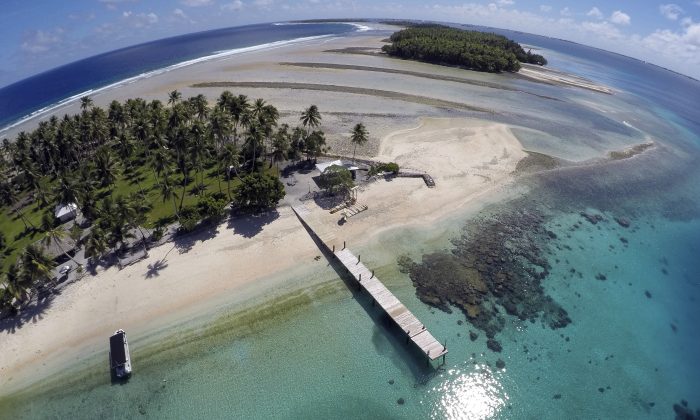 This Nov. 8, 2015 aerial photo shows a small section of the atoll that has slipped beneath the water line only showing a small pile of rocks at low tide on Majuro Atoll in the Marshall Islands. (AP Photo/Rob Griffith)