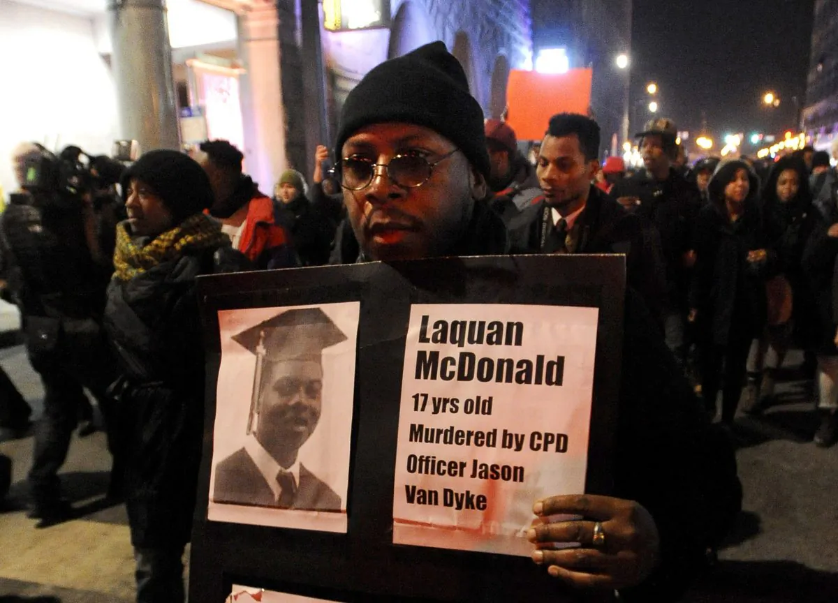 A protester holds a sign as people rally for 17-year-old Laquan McDonald, who was shot 16 times by Chicago Police Department Officer Jason Van Dyke in Chicago, on Nov. 24, 2015. (AP Photo/Paul Beaty)