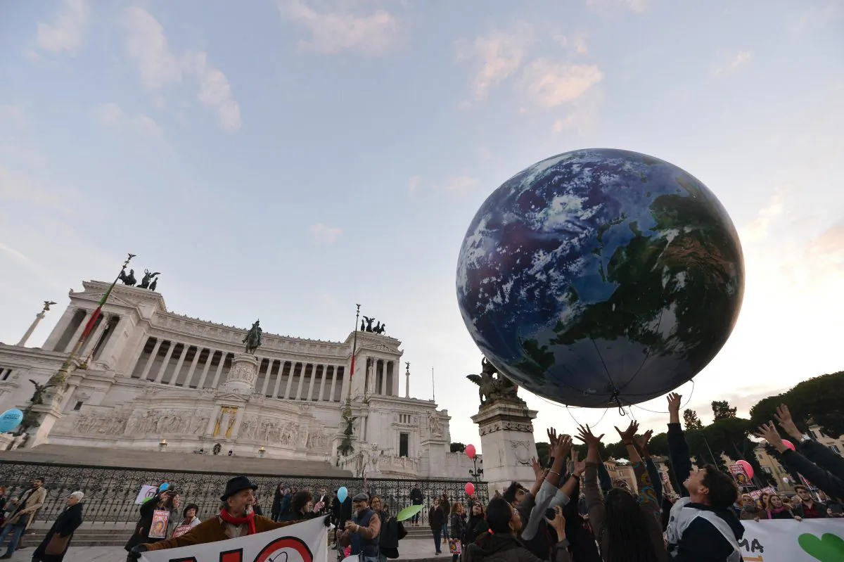 People play with a giant balloon representing Earth at Piazza Venezia during a rally calling for action on climate change on Nov. 29, 2015, in Rome a day before the launch of the COP21 conference in Paris. (Tiziana Fabi/AFP/Getty Images)
