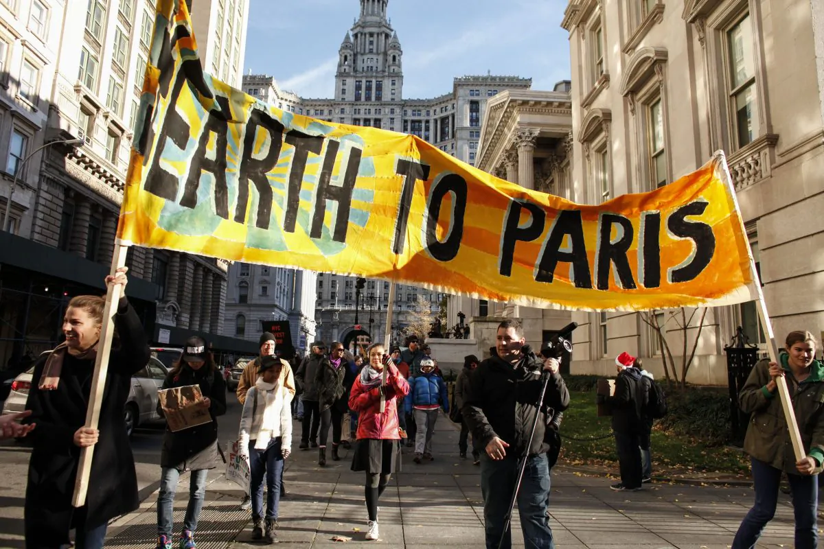 People hold a banner as they take part in a global climate march near City Hall on Nov. 29, 2015, in New York City. The protest is part of an international weekend of action that is being mobilized to support climate activists in Paris whose massive march has been prevented by French authorities due to the recent attacks. Around 570,000 people have already marched in 2,300 events in 175 countries around the world. (Kena Betancur/Getty Images)