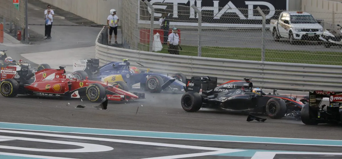 McLaren driver Fernando Alonso of Spain, second from right, , crashes with Lotus driver Pastor Maldonado of Venezuela as Ferrari driver Sebastian Vettel of Germany, left, and Sauber driver Felipe Nasr of Brazil run during the Emirates Formula One Grand Prix at the Yas Marina racetrack in Abu Dhabi, United Arab Emirates, Sunday, Nov. 29, 2015. (AP Photo/Luca Bruno)