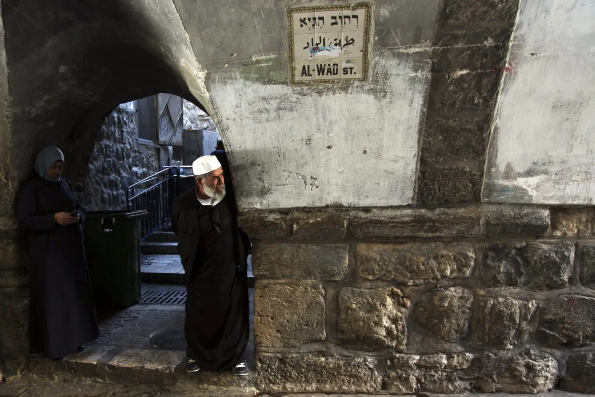 Palestinians look at the scene after a stabbing attack in Jerusalem's Old City Sunday, Mov. 29, 2015. A Palestinian stabbed an Israeli police officer in Jerusalem on Sunday before being shot dead by security forces, police said. (AP Photo/Mahmoud Illean)