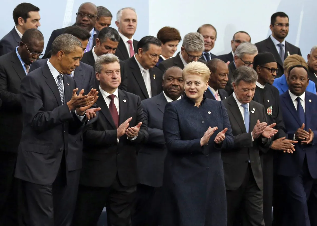 CORRECTS ID TO LITHUNIA PRESIDENT  U.S. President Barack Obama, left, and Lithuania's President Dalia Grybauskaite, front row third from right, applaud as they pose with world leaders for a group photo at the COP21, United Nations Climate Change Conference, in Le Bourget, outside Paris, Monday, Nov. 30, 2015. (AP Photo/Jacky Naegelen, Pool)