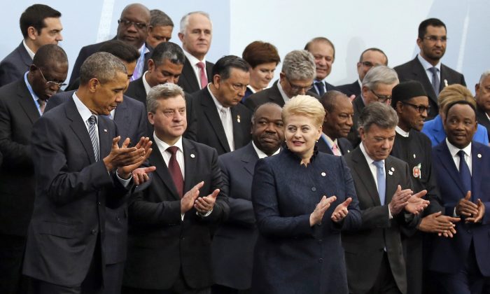 CORRECTS ID TO LITHUNIA PRESIDENT  U.S. President Barack Obama, left, and Lithuania's President Dalia Grybauskaite, front row third from right, applaud as they pose with world leaders for a group photo at the COP21, United Nations Climate Change Conference, in Le Bourget, outside Paris, Monday, Nov. 30, 2015. (AP Photo/Jacky Naegelen, Pool)