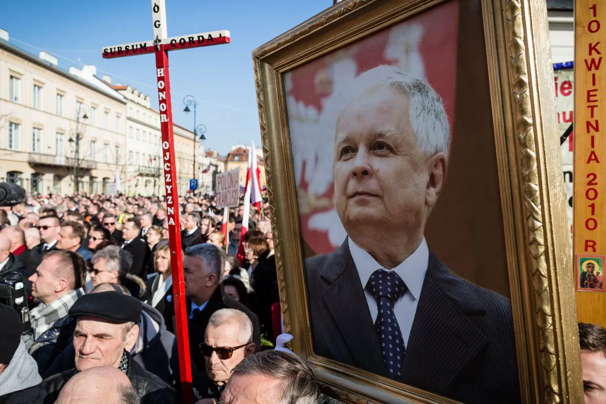 People hold a portrait of former Polish President Lech Kaczynski as they attend a ceremony marking the fifth anniversary of the presidential plane crash in Smolensk, in front of the presidential palace in Warsaw, on April 10, 2015. (Wojtek Radwanski/AFP/Getty Images)