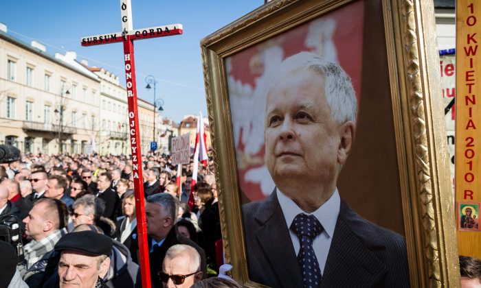 People hold a portrait of former Polish President Lech Kaczynski as they attend a ceremony marking the fifth anniversary of the presidential plane crash in Smolensk, in front of the presidential palace in Warsaw, on April 10, 2015. (Wojtek Radwanski/AFP/Getty Images)