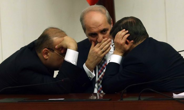 Members of new Turkish cabinet Deputy Prime Minister Yalçn Akdogan (L), Turkish Prime Minister Ahmet Davutoglu (R) and Deputy Prime Minister Numar Kurtulmus (C) talks during a session of the Turkish Parliament in Ankara on Nov. 30, 2015. (Adem Altan/AFP/Getty Images)