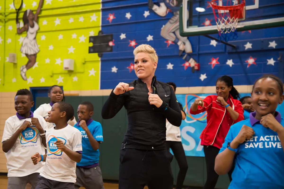 Singer Pink exercises with students from PS 242 Young Diplomats Magnet Academy at the launch of UNICEF Kid Power in New York on Monday, Nov. 30, 2015. (Charles Sykes/Invision via AP)