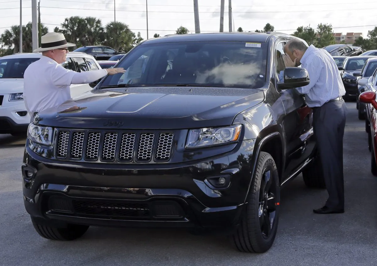 Salesperson Andrew Montalvo (L) talks to a customer checking out the interior of a 2015 Grand Cherokee Limited in Doral, Fla., on Nov. 5, 2015. Fiat Chrysler sales are up in what could be a record in November. (AP Photo/Alan Diaz)