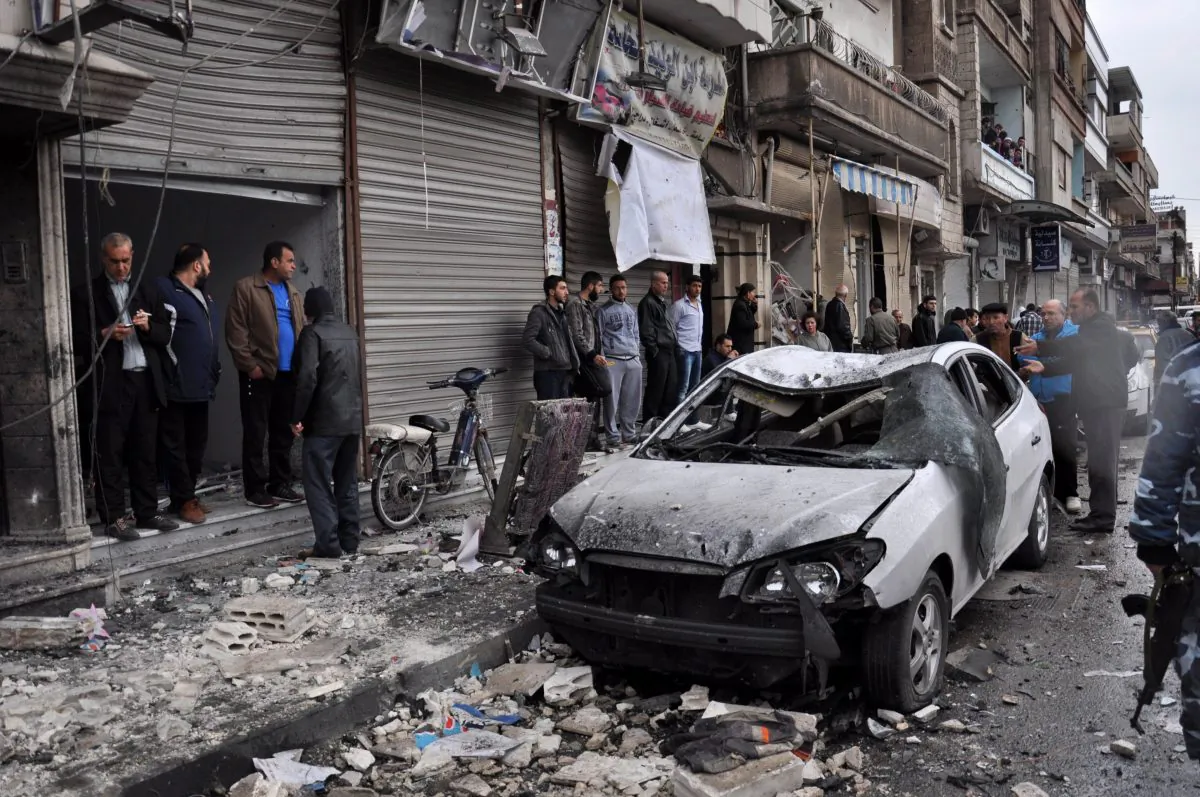 Syrian residents and security forces inspect the damage following a car bomb explosion on April 10, 2015, in the government-controlled majority Alawite neighbourhood of Hay al-Arman, located on the outskirts of the Zahraa district in Homs city. (AFP/Getty Images)