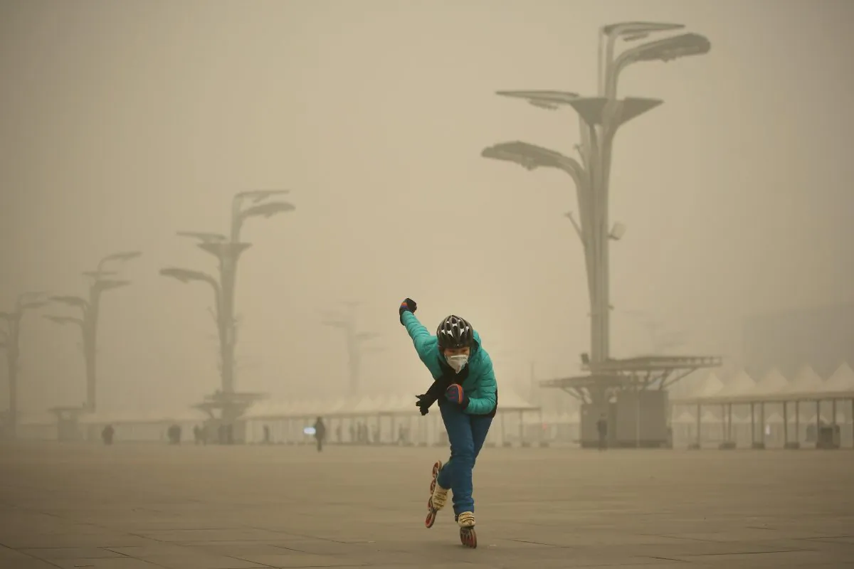 A woman wearing a mask practices roller blading at Olympic Park during heavy smog  in Beijing, China, on Dec. 1, 2015. (Li Feng/Getty Images)