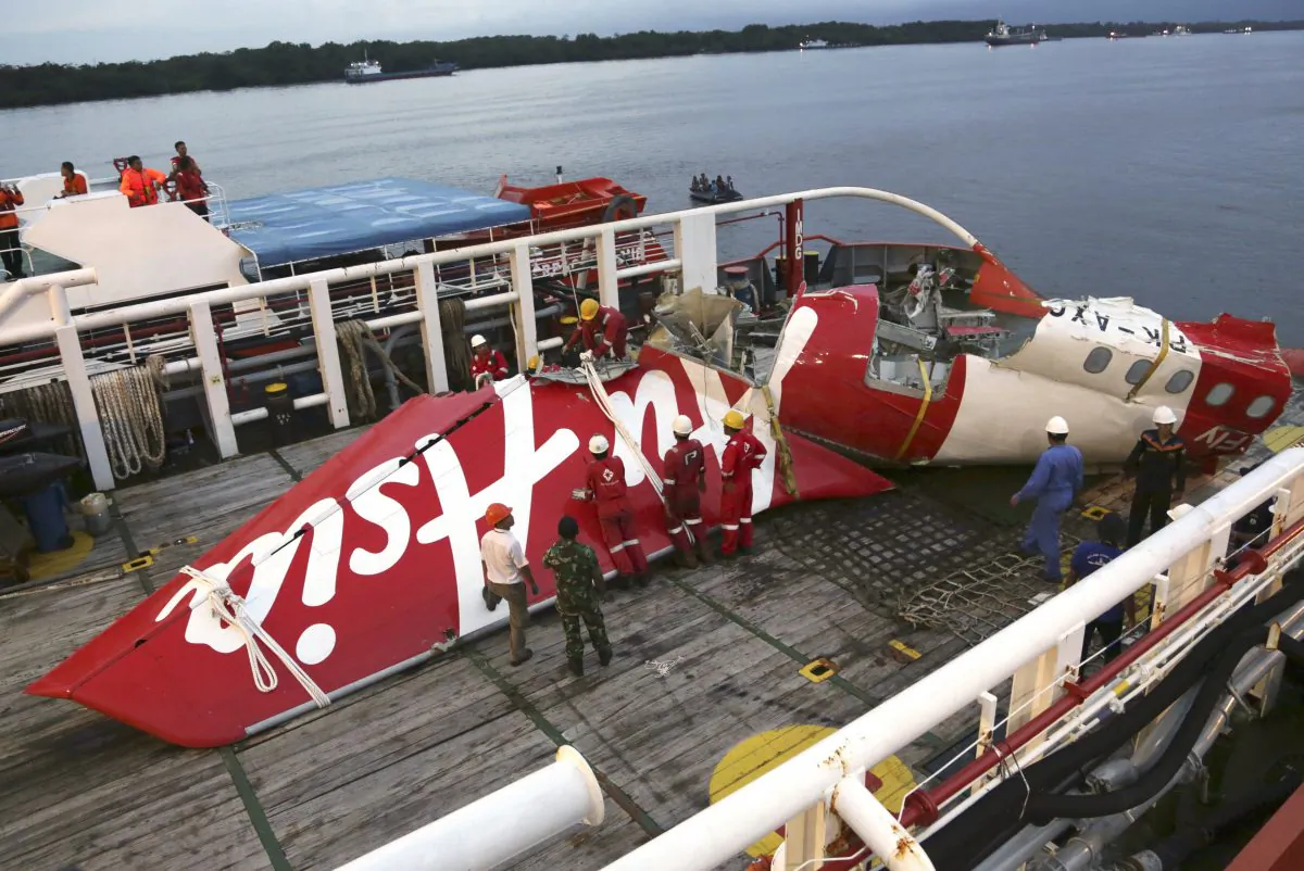 In this Sunday, Jan.11, 2015 file photo, crew members of Crest Onyx recovery ship prepare to unload the newly-recovered tail section of crashed AirAsia Flight 8501 at Kumai port in Pangkalan Bun, Central Borneo, Indonesia. (AP Photo/Achmad Ibrahim)