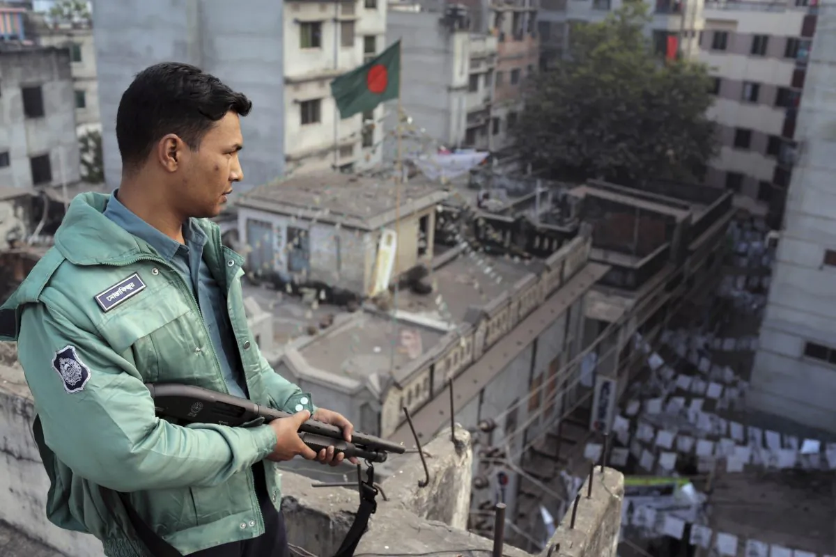A Bangladeshi policeman stands guard on the rooftop of a polling center in Dhaka, Bangladesh, on Jan. 5, 2014. (AP Photo/A.M. Ahad)
