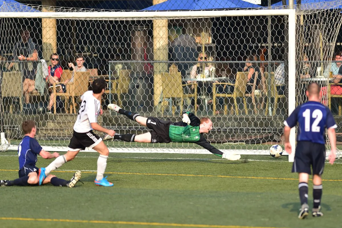 GAS No 22 scores their second goal just before half time past Wanderers goalkeeper Freddie Toomer during their 3-all top of the table clash in the Yau Yee League First division match at Sports Road on Sunday Nov 29, 2015.
(Bill Cox/Epoch Times)