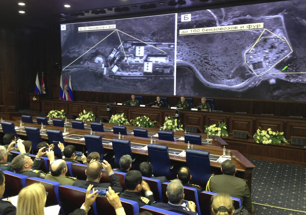 Russian top military officials speak to the media in front of an aerial images they say are oil trucks near Turkey’s border with Syria displayed by the Russian Defense Ministry at a briefing in Moscow, Russia, Wednesday, Dec. 2, 2015. The Russian Defense Ministry invited dozens of foreign military attaches and hundreds of journalists to reveal what they said were satellite and aerial images of thousands of oil trucks streaming from the ISIS-controlled deposits in Syria and Iraq into Turkish sea ports and refineries. Russian Deputy Defense Minister Anatoly Antonov accused Turkish President Recep Tayyip Erdogan and his family of personally profiting from the oil trade with the Islamic State. (AP Photo/Vladimir Kondrashov)