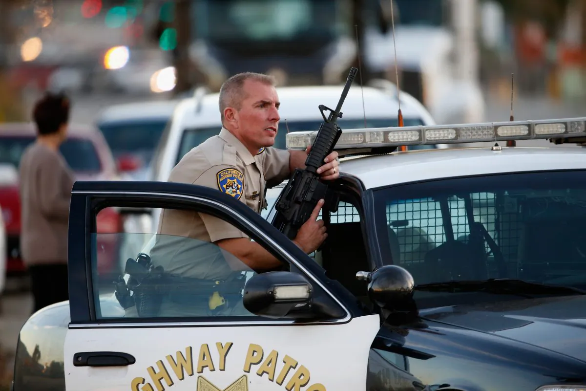 A California Highway Patrol officer stands with his weapon as authorities pursued the suspects in a shooting that occurred at the Inland Regional Center in San Bernardino, Calif., on Dec. 2, 2015. (Sean M. Haffey/Getty Images)