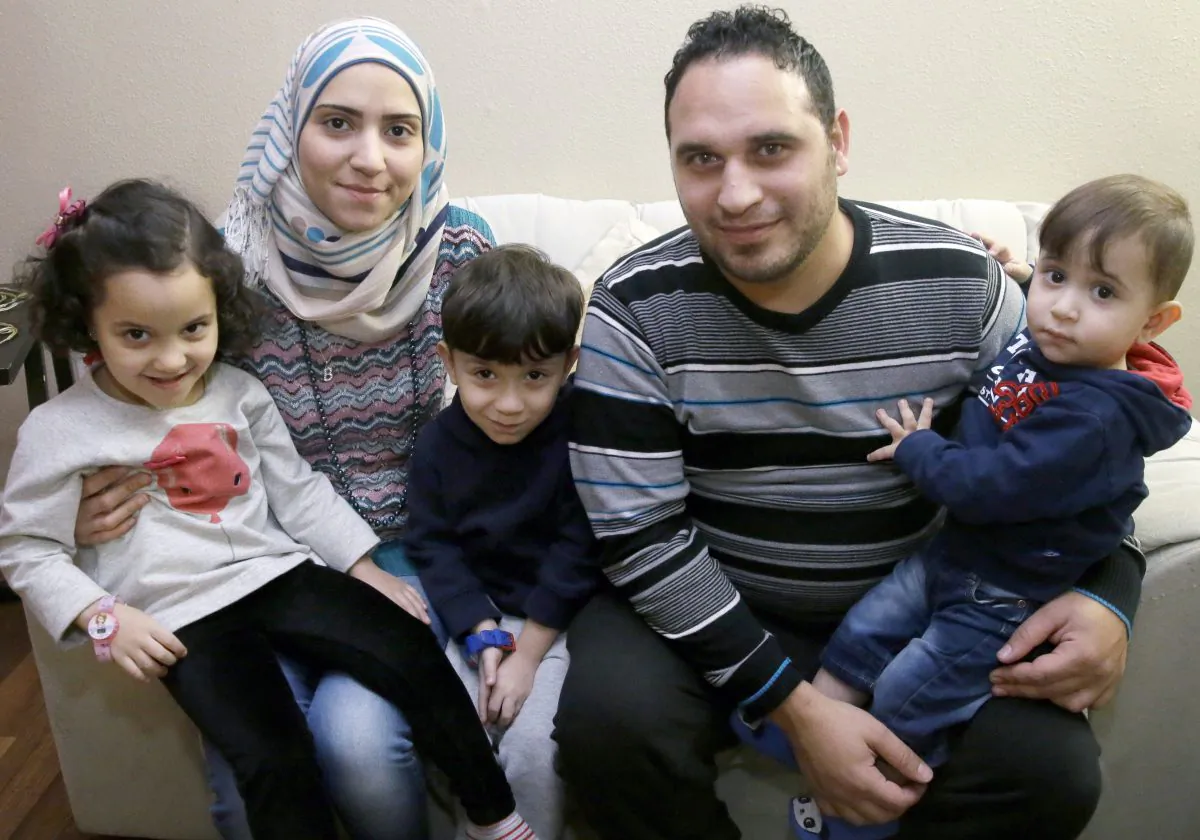 In this photo made Monday, Nov. 29, 2015, Syrian refugee Bashar al Jaddou, second from right, poses for a photo with his wife Maryam, second from left, and their children twins Maria, left, Hasan, center, and Mohammad word at their apartment in Dallas. (AP Photo/LM Otero)