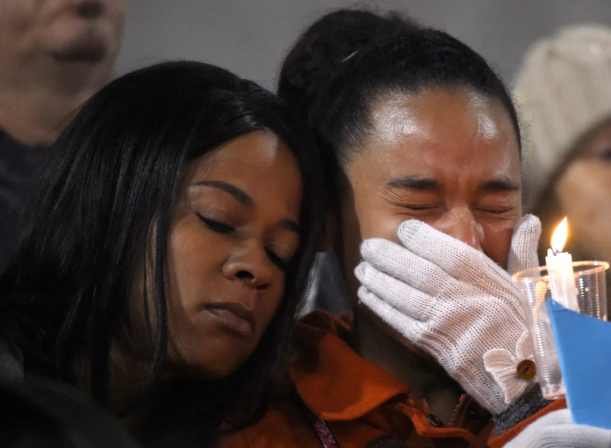 A woman cries during a candlelight vigil for shooting victims on Thursday, Dec. 3, 2015, at San Manuel Stadium in San Bernardino, Calif. A husband and wife opened fire on a holiday banquet, killing multiple people on Wednesday. Hours later, the couple died in a shootout with police. (AP Photo/Mark J. Terrill)
