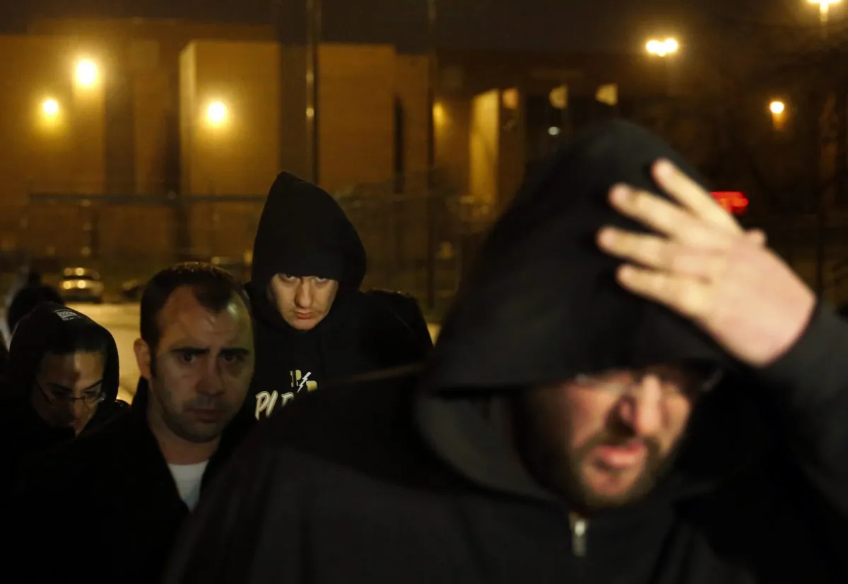 Chicago Police Officer Jason Van Dyke (background center) leaves the Cook County Jail after posting bond in Chicago on Nov. 30, 2015. Van Dyke has been locked up since Nov. 24, when prosecutors charged him with first-degree murder in the shooting death of black teenager Laquan McDonald. (AP Photo/Charles Rex Arbogast)